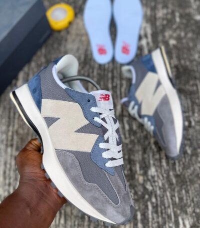 A pair of grey, white, and blue New Balance 574 sneakers, perfect for men's casual wear, with a comfortable fit and stylish design.