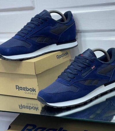 A pair of navy blue Reebok Classic sneakers on display, showcasing their sleek design and comfortable features.