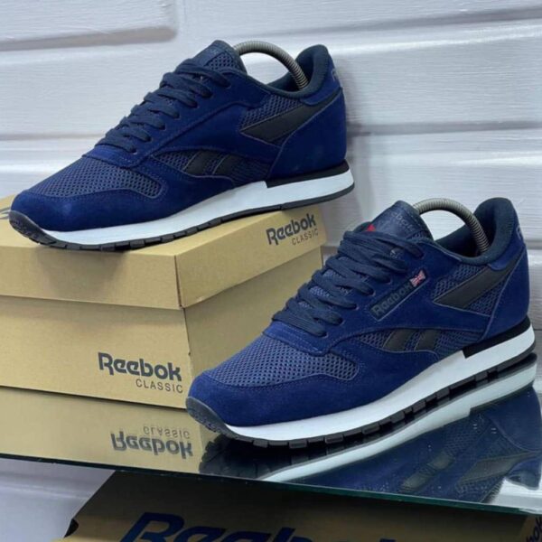 A pair of navy blue Reebok Classic sneakers on display, showcasing their sleek design and comfortable features.