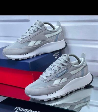 A pair of grey and white Reebok sneakers on display, showcasing their sleek design and comfortable features.