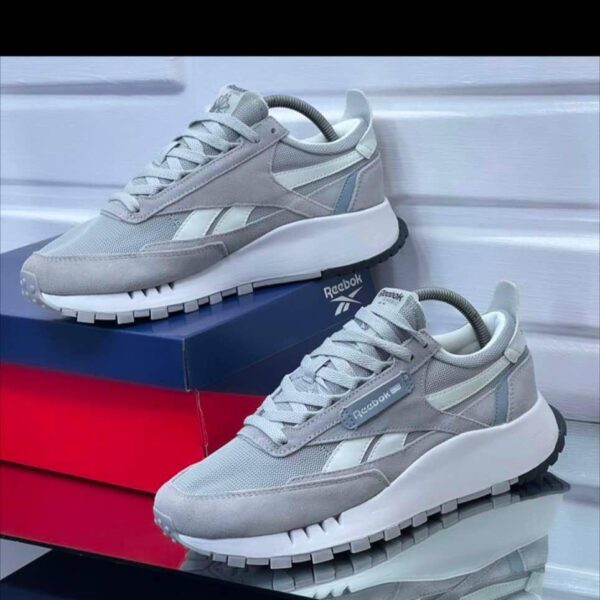 A pair of grey and white Reebok sneakers on display, showcasing their sleek design and comfortable features.