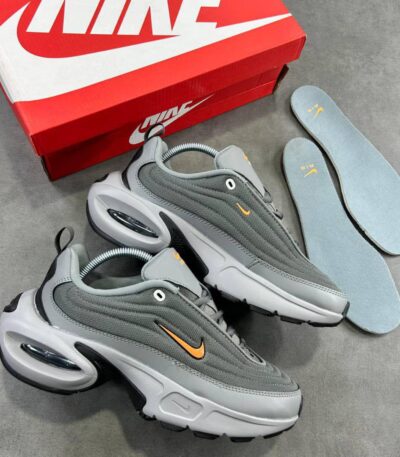 Grey and orange Nike Air Max 270 React sneakers with box and insoles on a grey background.