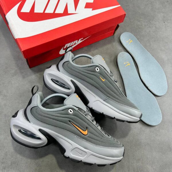 Grey and orange Nike Air Max 270 React sneakers with box and insoles on a grey background.