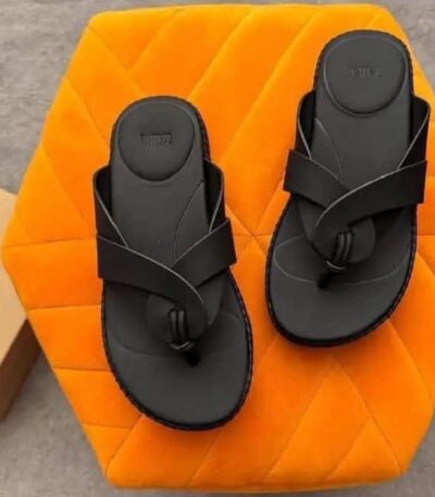 A pair of black double strap sandals on an orange hexagonal pillow with a shoe box, showcasing ArvoLuxury's premium design and comfort.