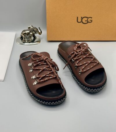 A pair of black leather open-toe sandals with metal buckles and laces, exuding luxury and sophistication.