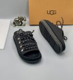 A pair of black leather open-toe sandals with metal buckles and laces, exuding luxury and sophistication.