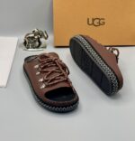 A pair of black leather open-toe sandals with metal buckles and laces, exuding luxury and sophistication.