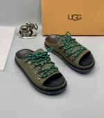 A pair of black leather open-toe sandals with metal buckles and laces, exuding luxury and sophistication.