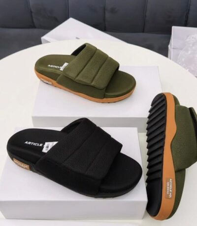 A pair of olive green and black slide sandals displayed on white shoe boxes, showcasing the comfort and style of ArvoLuxury's premium footwear.