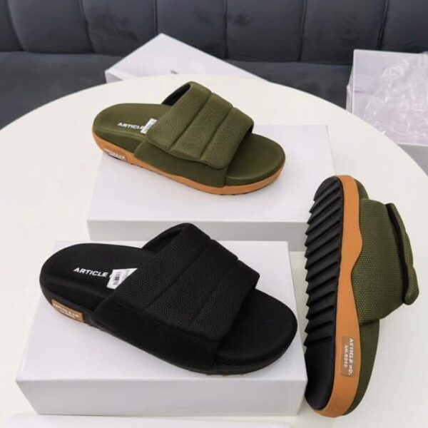 A pair of olive green and black slide sandals displayed on white shoe boxes, showcasing the comfort and style of ArvoLuxury's premium footwear.