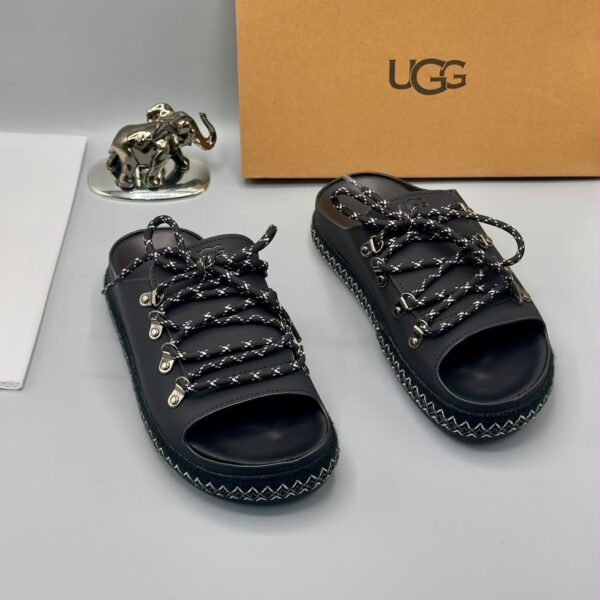 A pair of black leather open-toe sandals with metal buckles and laces, exuding luxury and sophistication.