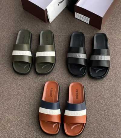 A display of three pairs of Pedro two-strap slide sandals in olive green, black, and terracotta, with their respective shoe boxes.