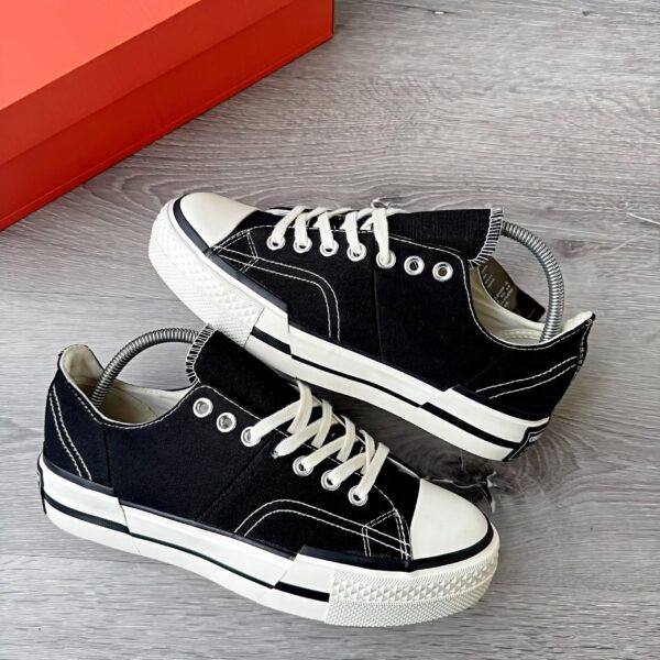 A pair of black sneakers with white laces and rubber soles, exuding luxury and comfort.